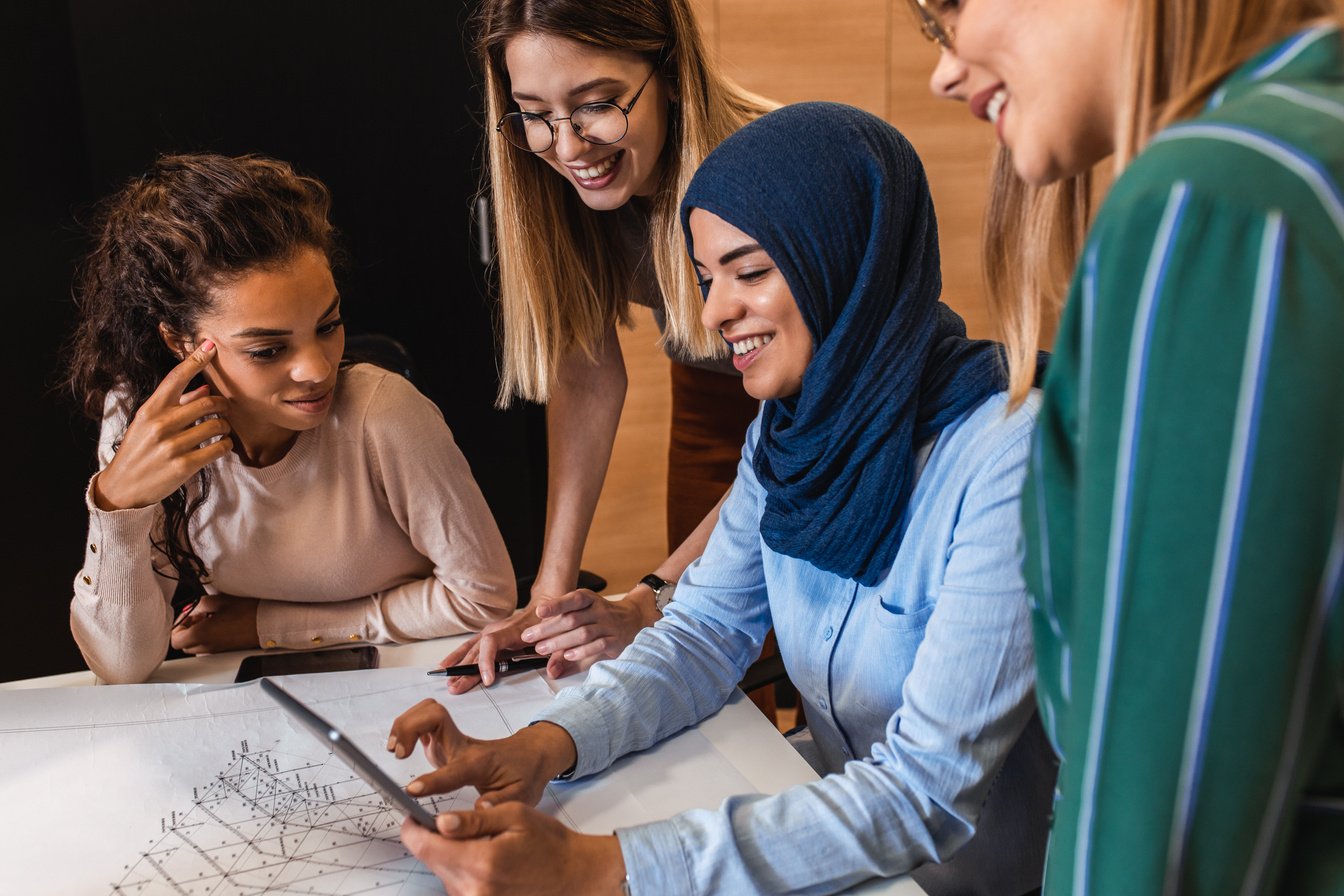 Group of modern multicultural young women in creative office.